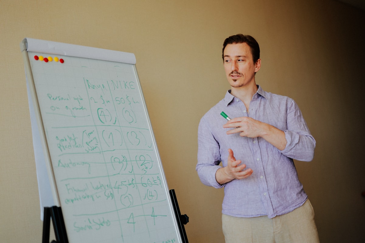 A leader presenting ideas on a whiteboard during a team meeting, illustrating the discovery phase of a new CTO role