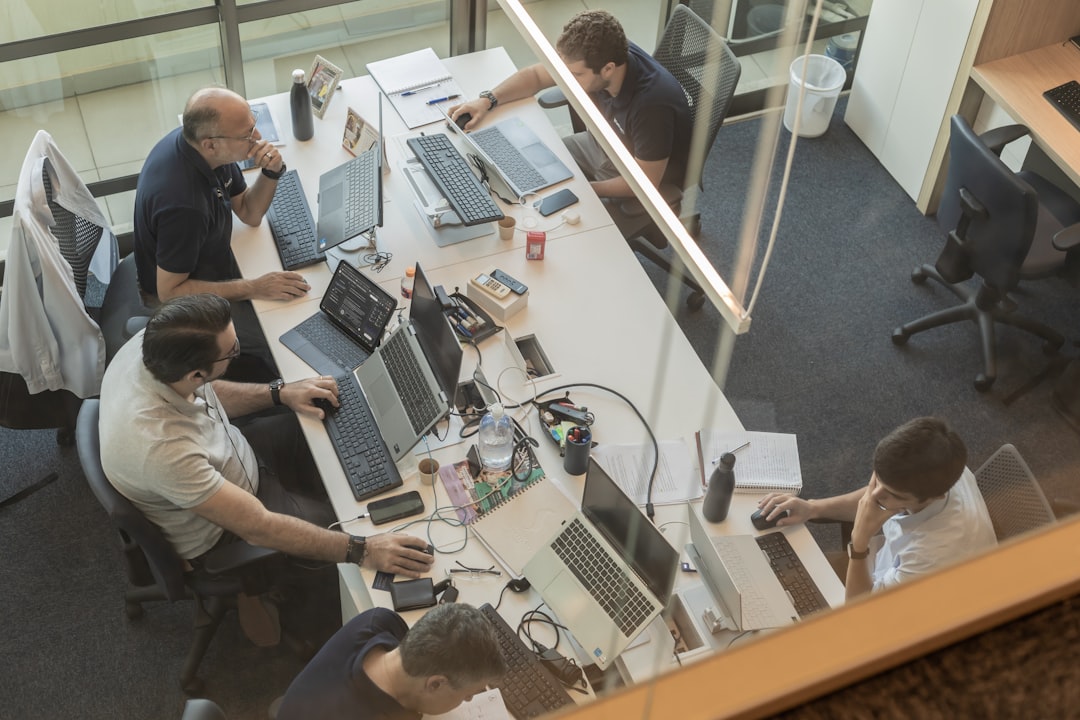 Four people working at desks in a modern open-plan office