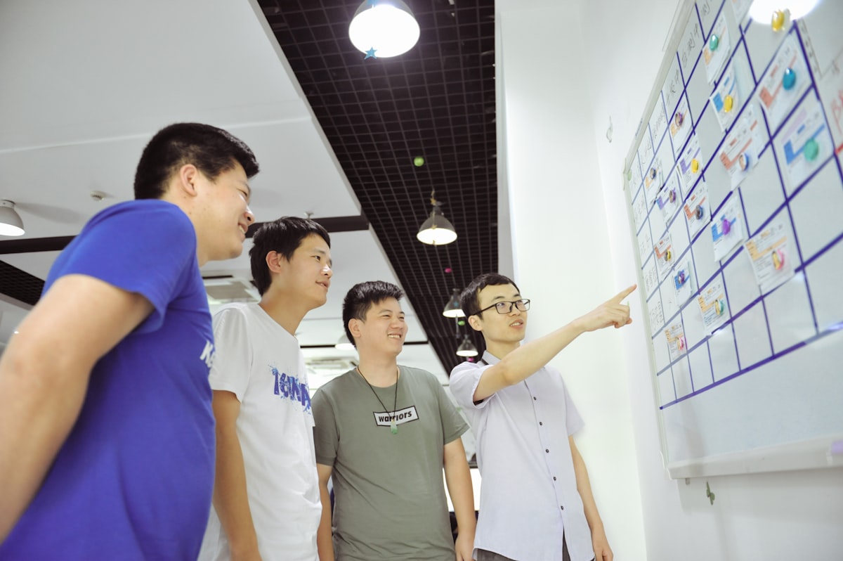 A cross-functional team collaborating around a whiteboard with sticky notes, representing the executive alignment a CTO must build