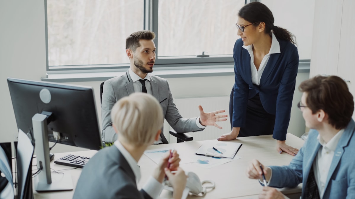 Business professionals collaborating in a meeting, representing the cross-functional governance needed to manage AI browser extension risks