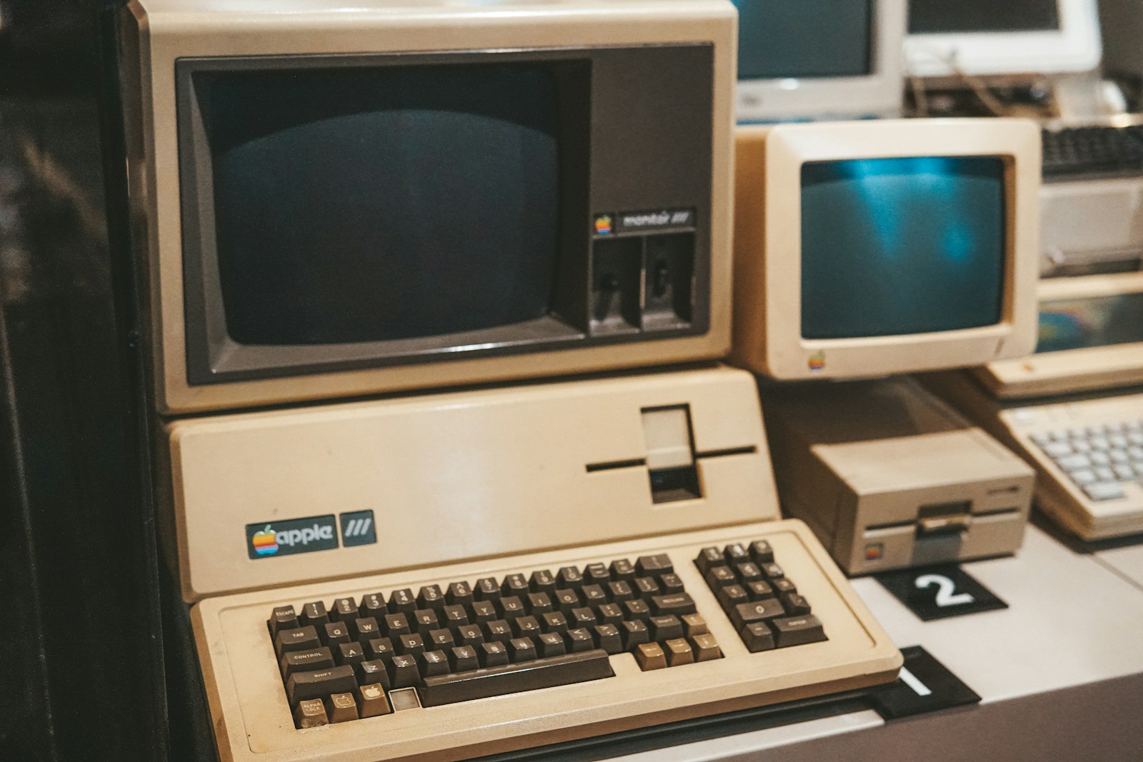 A row of vintage computer terminals on a desk