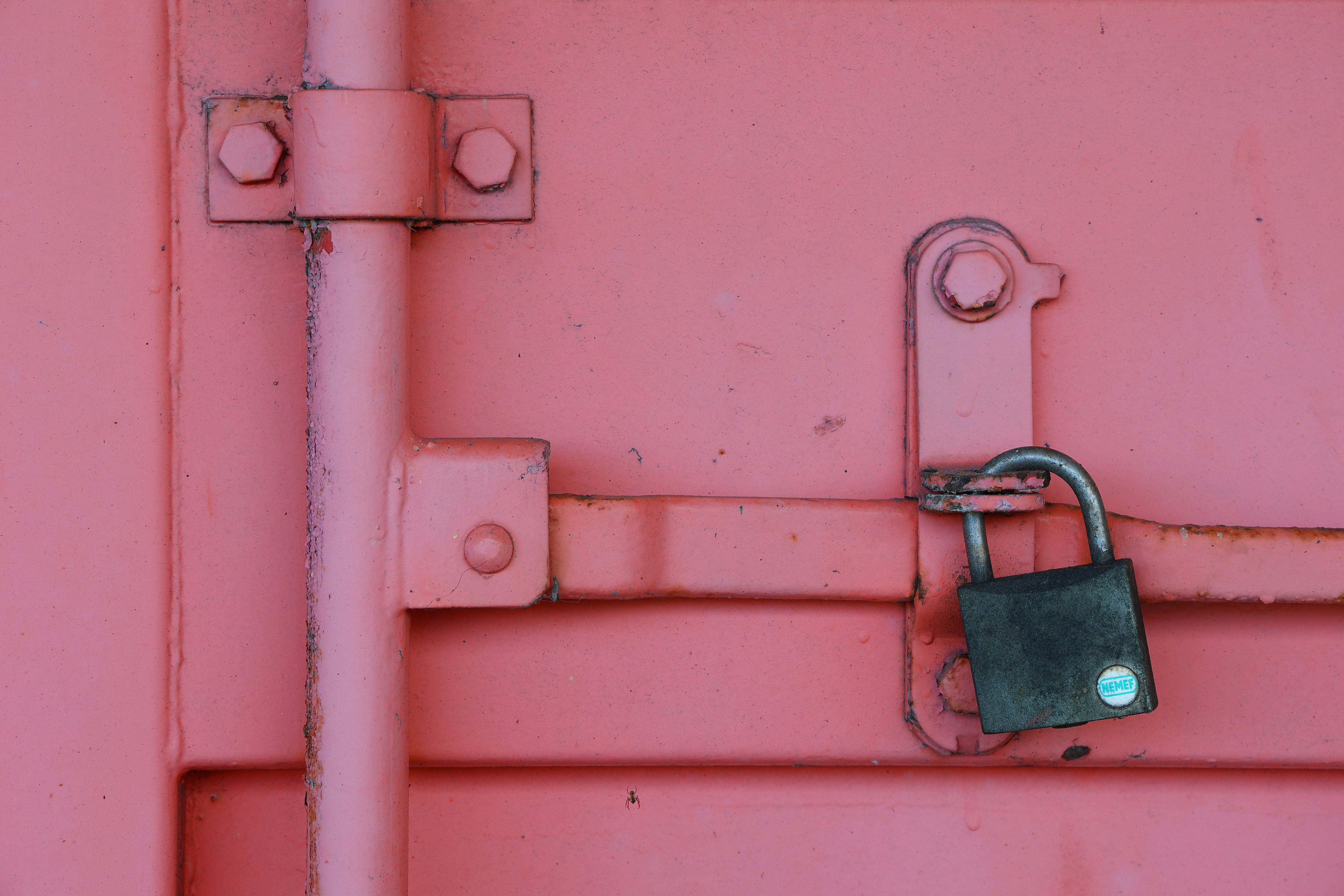 Close-up of a padlock on a pink surface, symbolizing Meta's shift from open to closed AI models