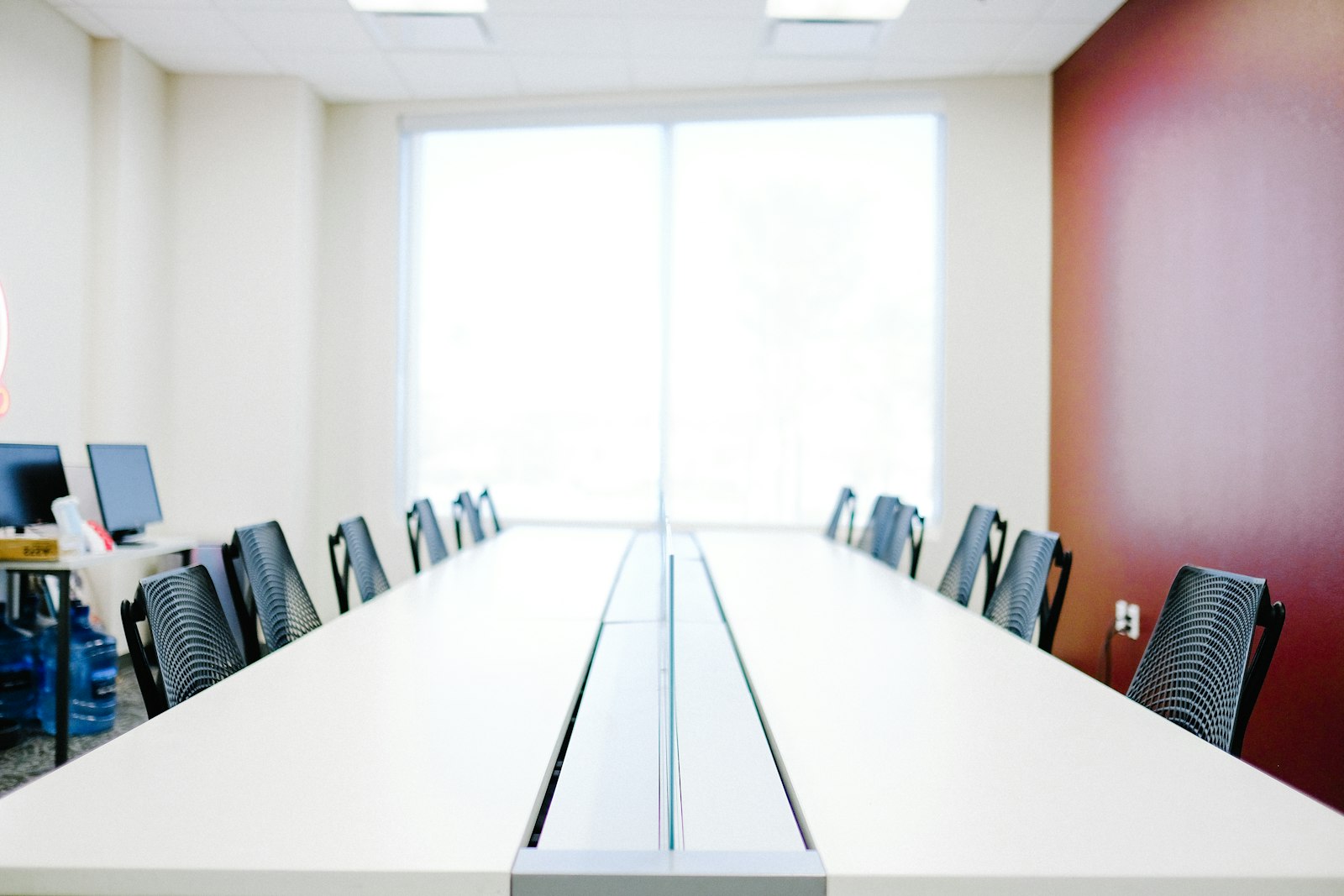 An empty meeting room with a long white table, suggesting the missing evaluators needed to absorb new AI safety funding
